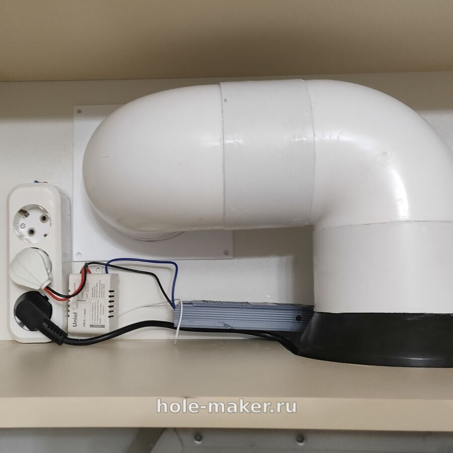 Воздуховод вытяжки в шкафу и накладная розетка, в которую включены вытяжка и подсветка